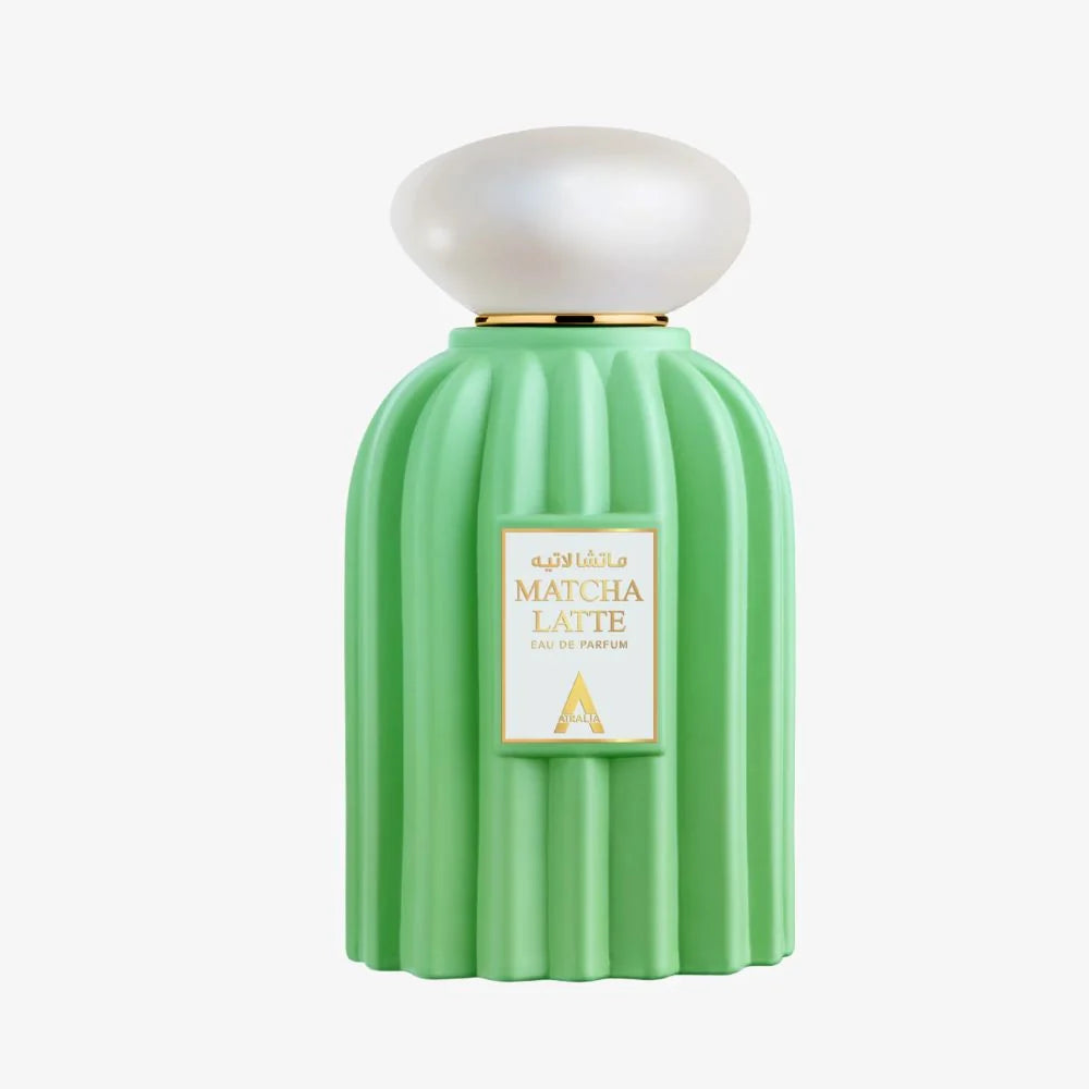 Frontal view of the pastel-green fluted flacon displaying a gold-bordered white label framed with gold typography that reads "MATCHA LATTE EAU DE PARFUM ATRALIA", crowned with an iridescent pearlescent cap.